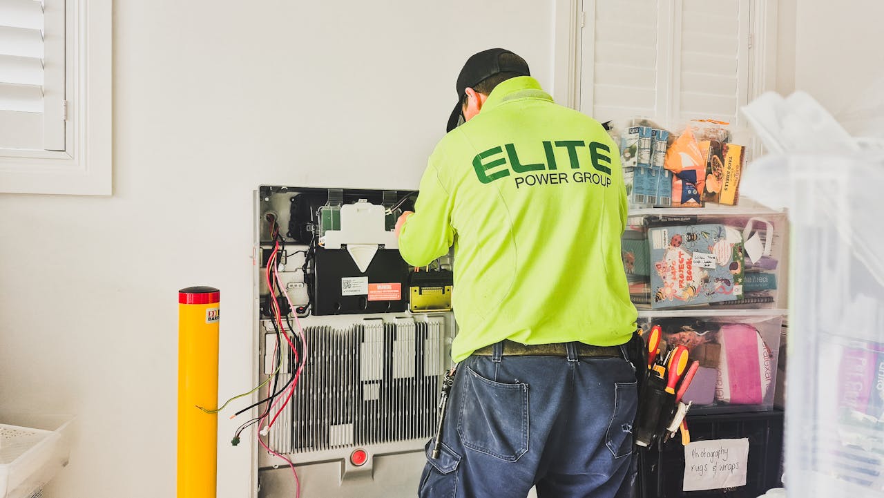 services-04 A technician from Elite Power Group installing a home battery system indoors in New South Wales, Australia.